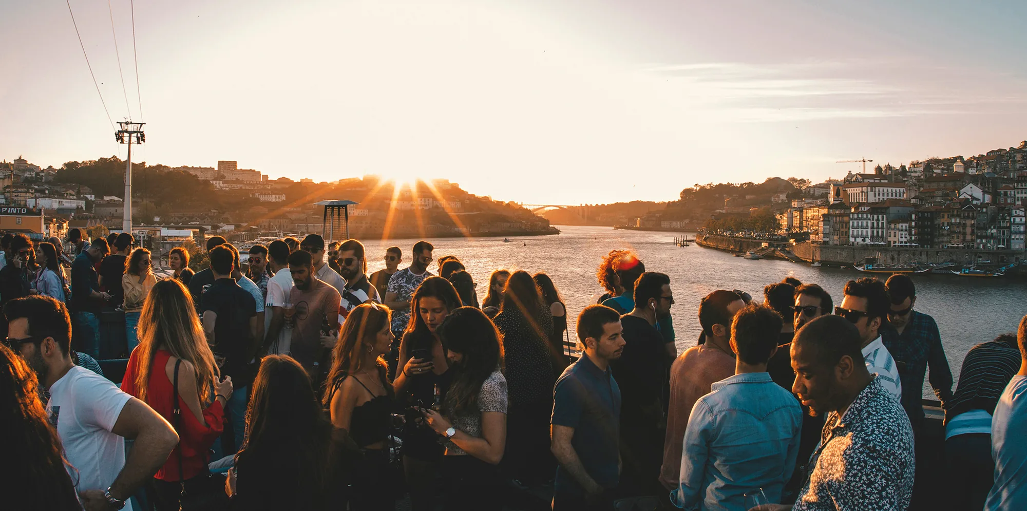 Guests enjoying sunset drinks on the Espaço Porto Cruz rooftop overlooking the Douro River and Porto