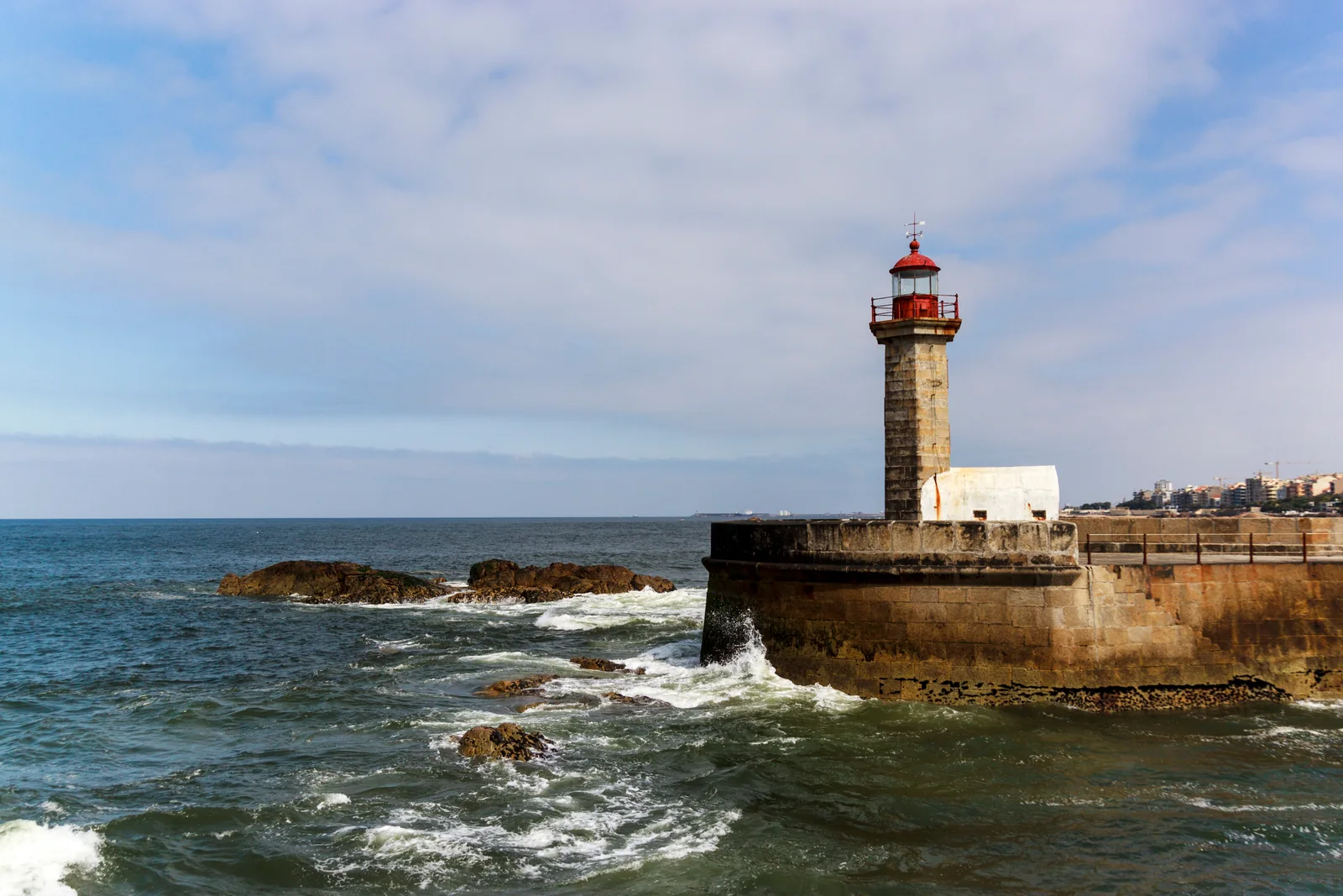 Lighthouse and Atlantic waves at Foz do Douro, where the Douro River meets the ocean