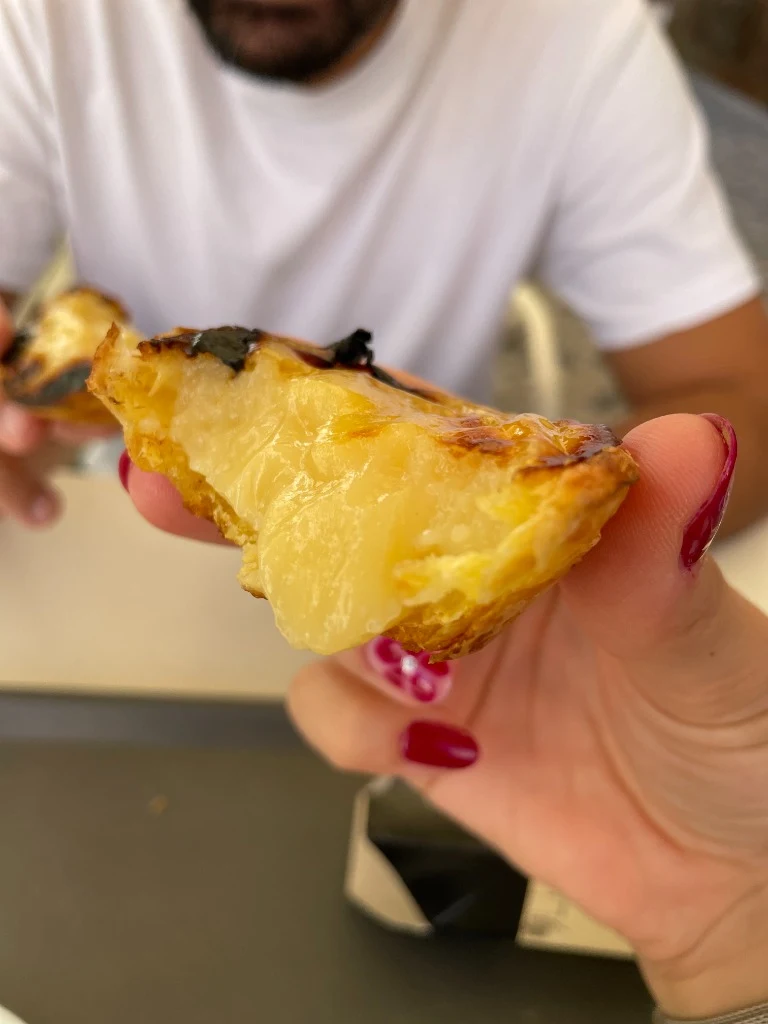 Fresh warm pastel de nata from Manteigaria with crisp flaky crust and creamy custard filling